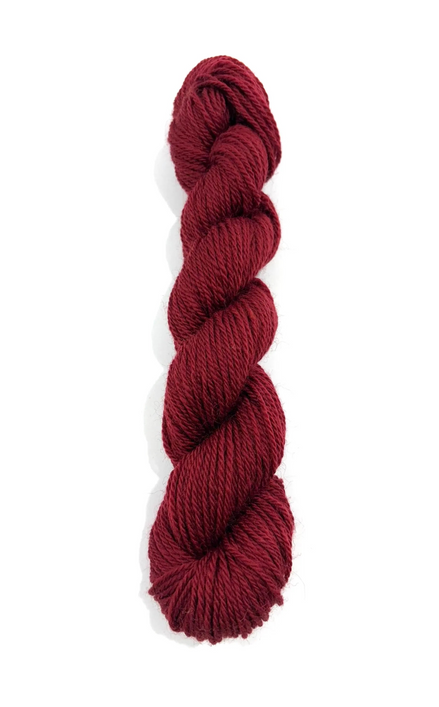 A single skein of deep burgundy yarn, twisted into a ply, shown vertically against a plain white background.