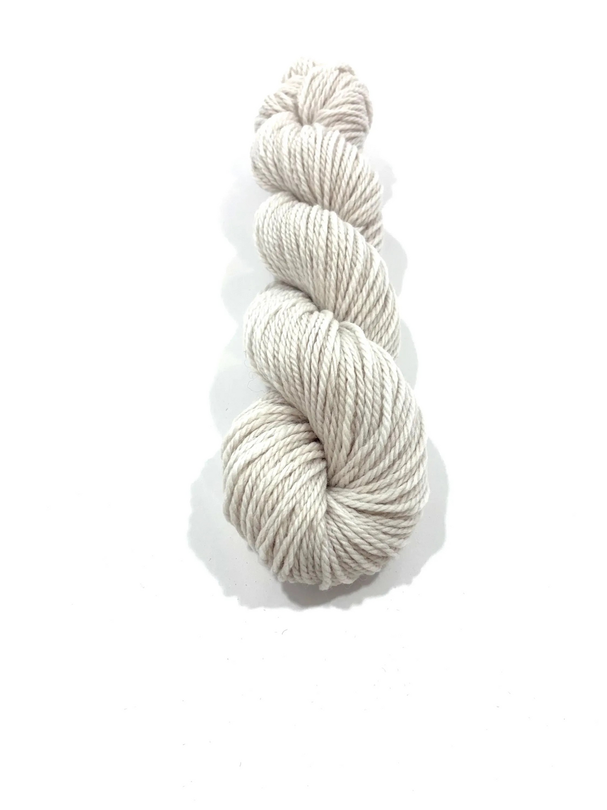 A single skein of twisted yarn in a light oatmeal beige color, photographed vertically against a clean white background with a soft drop shadow.