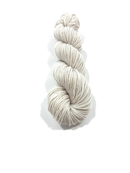 A single skein of twisted yarn in a light oatmeal beige color, photographed vertically against a clean white background with a soft drop shadow.