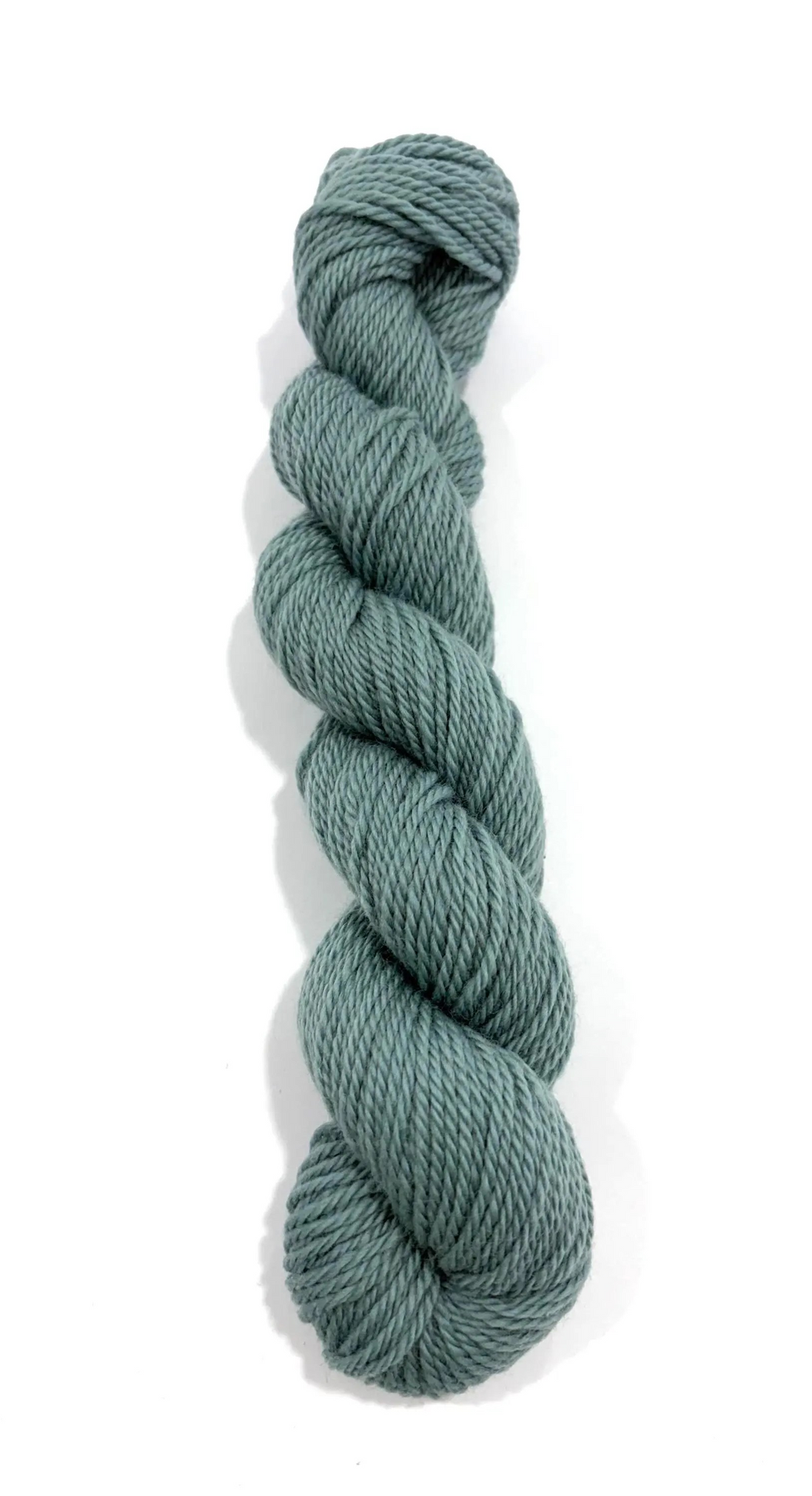 A single skein of twisted yarn in a muted sage green color, photographed vertically against a plain white background.
