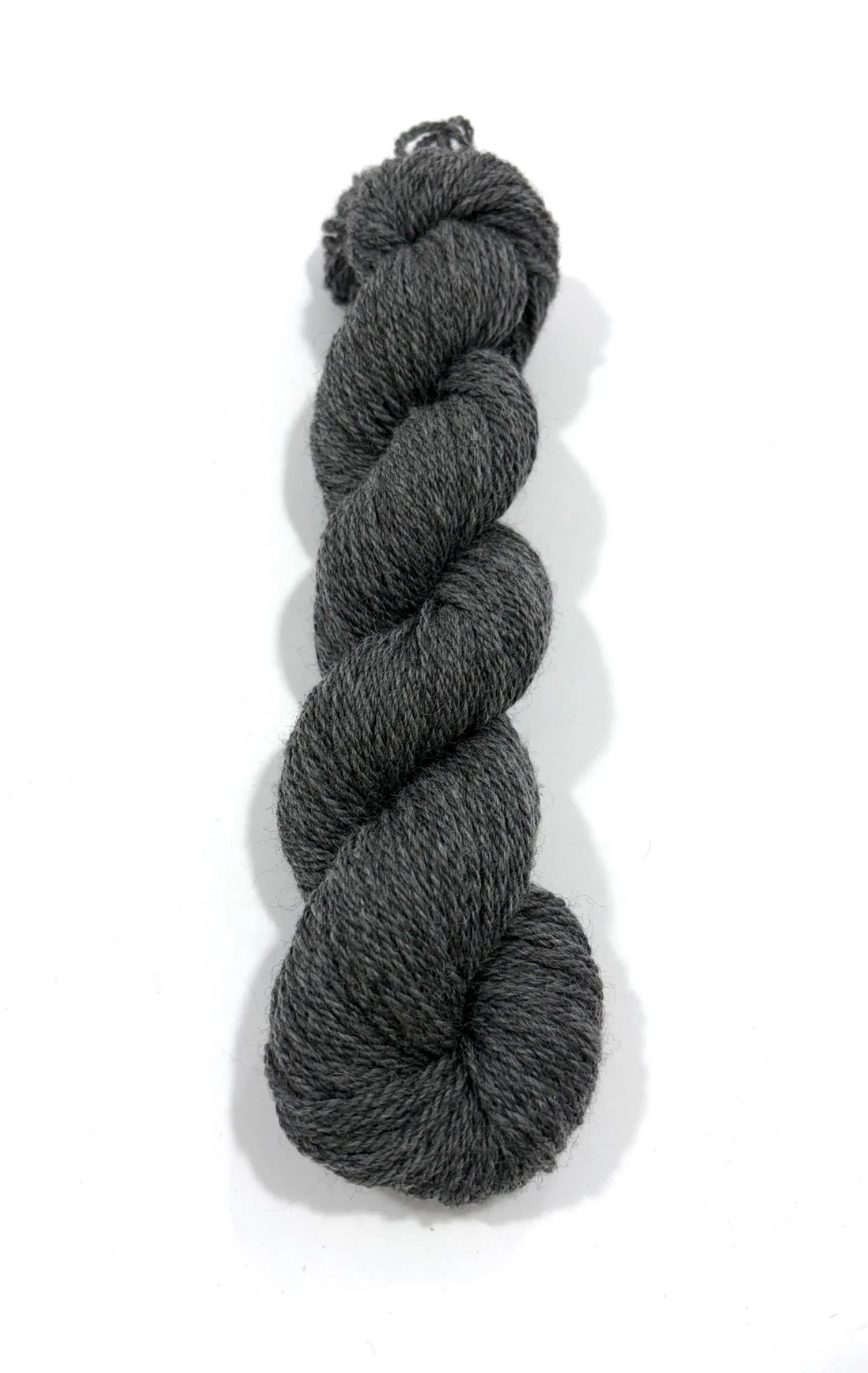 A single skein of dark charcoal gray heathered yarn, twisted into a braid, photographed on a clean white background with a soft drop shadow.