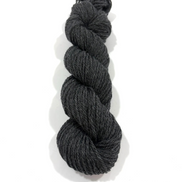 A single skein of dark charcoal gray yarn, twisted into a braid, shown on a clean white background with a soft drop shadow.