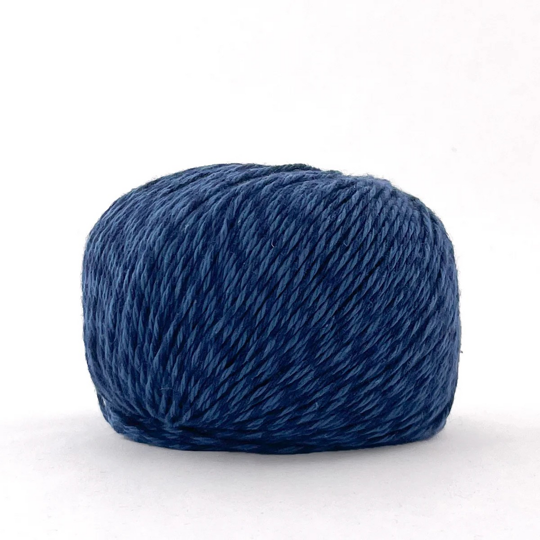 A single ball of twisted yarn in a deep navy blue color, photographed against a clean white background.