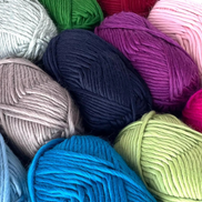 Bulky Weight Yarn 100% Merino Wool Super Bulky Yarn Weight 6 Chunky Natural Wool Yarn for Knitting & Crochet Quick Project Yarn. A close-up arrangement of multiple skeins of yarn in assorted colors, including pink, blue, green, purple, beige, orange, and white, filling the frame.