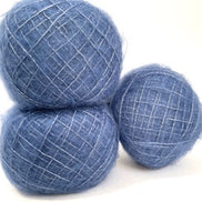 Three balls of fluffy blue yarn with subtle white flecks, arranged on a plain white background.