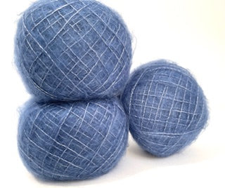Three balls of fluffy blue yarn with subtle white flecks, arranged on a plain white background.