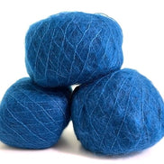 Three balls of vibrant blue yarn stacked together on a plain white background.