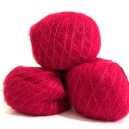 Three balls of vibrant magenta pink yarn stacked together on a plain white background.
