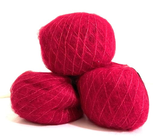 Three balls of vibrant magenta pink yarn stacked together on a plain white background.