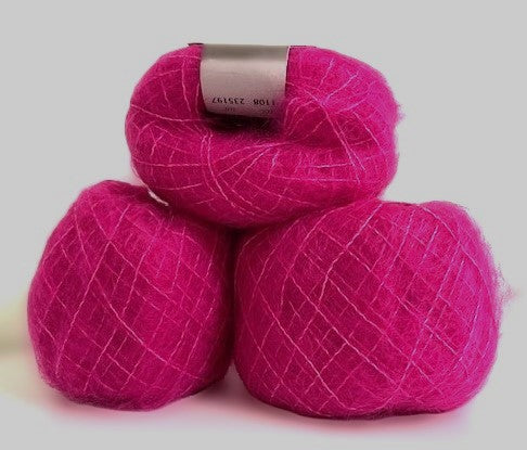 Three balls of bright magenta pink yarn stacked together on a light gray background. The top ball has a silver paper label wrapped around it.
