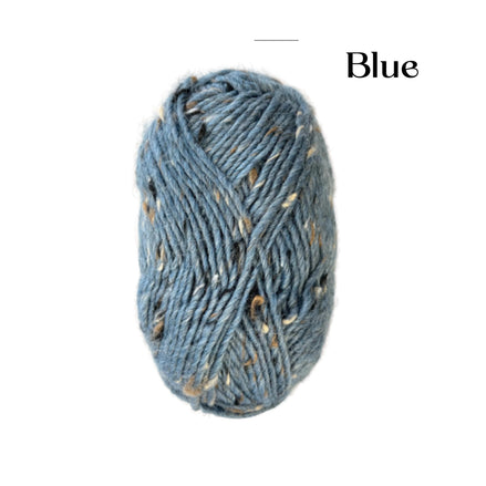 A skein of heathered blue yarn with flecks of beige and brown, shown on a plain white background with the word 'Blue' printed in the upper right.