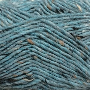 Close-up of teal blue yarn with small brown and black flecks throughout, filling the entire frame.