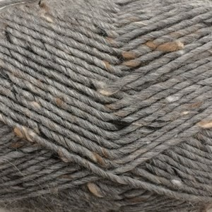 Close-up of a gray yarn skein with small natural brown and white inclusions woven throughout.
