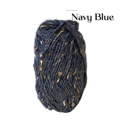 A skein of variegated yarn in a colorway labeled 'Navy Blue' on a plain white background. The yarn is a dark navy blue with flecks of tan, brown, and cream.