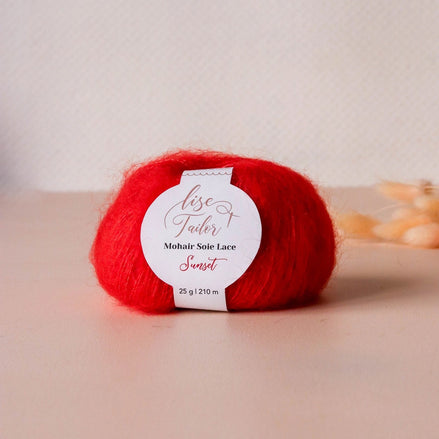 Red yarn ball with a label on a beige surface