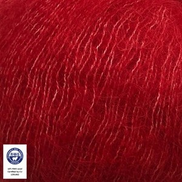 A close-up of bright red yarn texture with a small white certification label in the bottom-left corner.