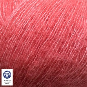 A close-up of soft pink yarn strands filling the frame, with a small certification label in the lower-left corner.