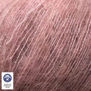 A close-up of dusty rose pink mohair yarn strands, showing its soft, fuzzy texture. A small white circular certification logo is visible in the bottom-left corner.