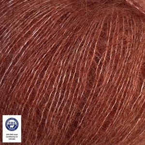 A close-up of reddish-brown hair fibers, likely demonstrating a hair dye or wig color, with a small certification label in the bottom-left corner.