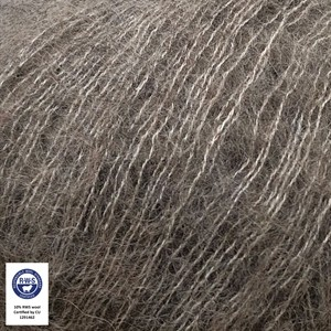 Close-up of a textured gray and white fuzzy fiber material, likely a hair or fur blend, with a small certification label in the bottom-left corner.