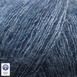 Close-up of a fuzzy, textured yarn or fiber in a heathered blue-gray color, with a small certification-style logo in the lower-left corner.